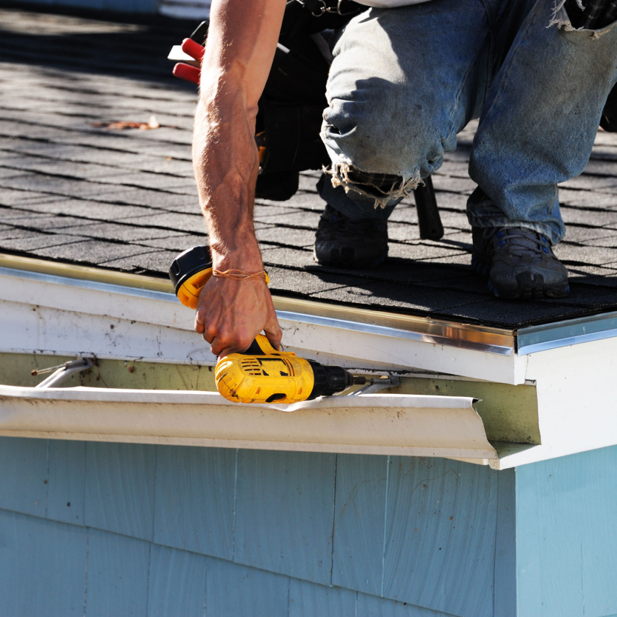 A man repairing roof gutters